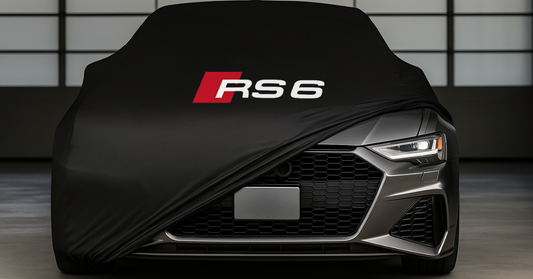 Audi RS6 covered with a custom-fit indoor car cover, partially open on one side, with RS6 logo centered on the hood, inside a luxury garage.